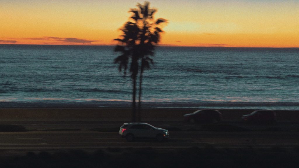Drone image of car driving at sunset for music video production